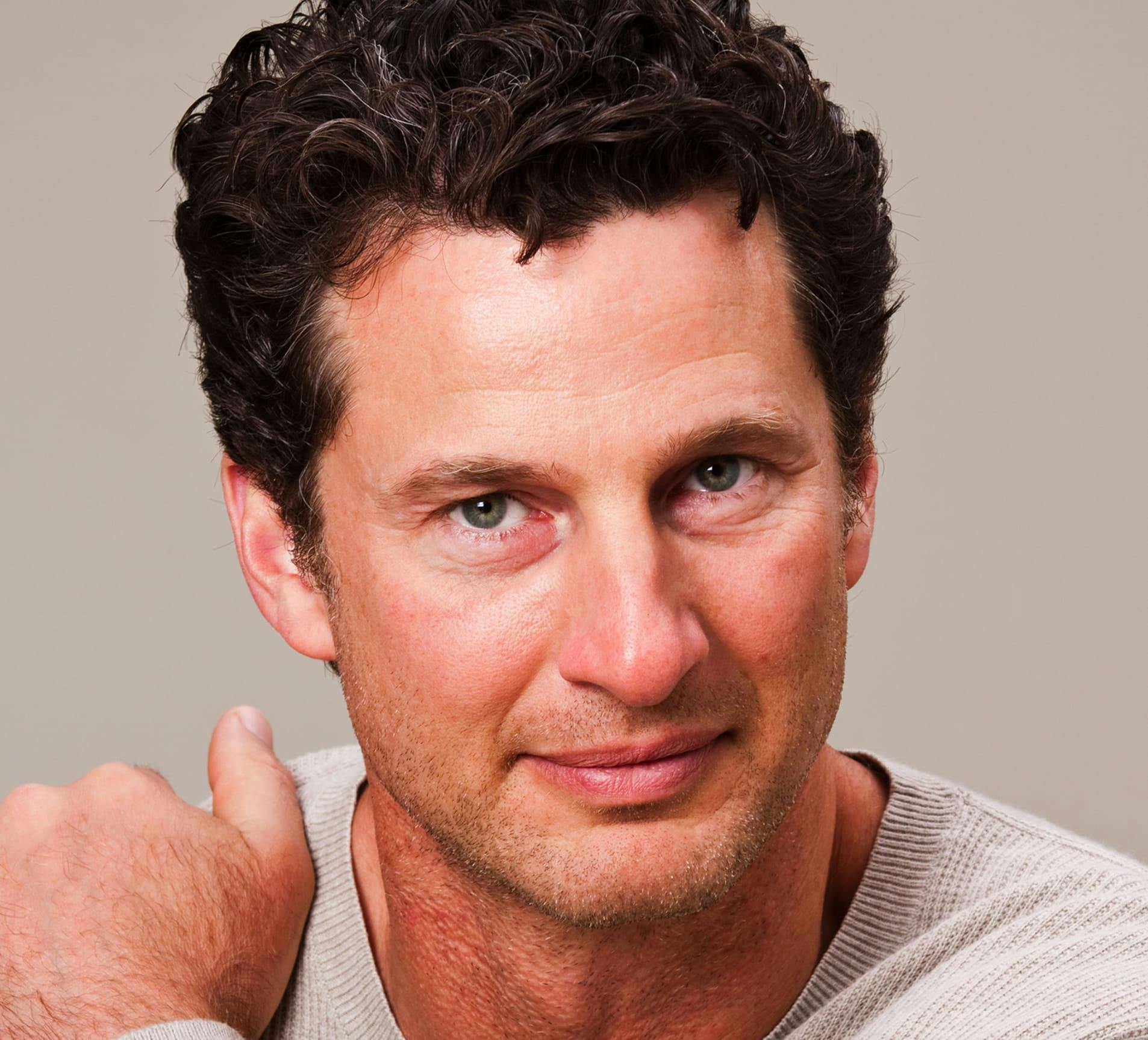 man looking forward with his hand on his shoulder