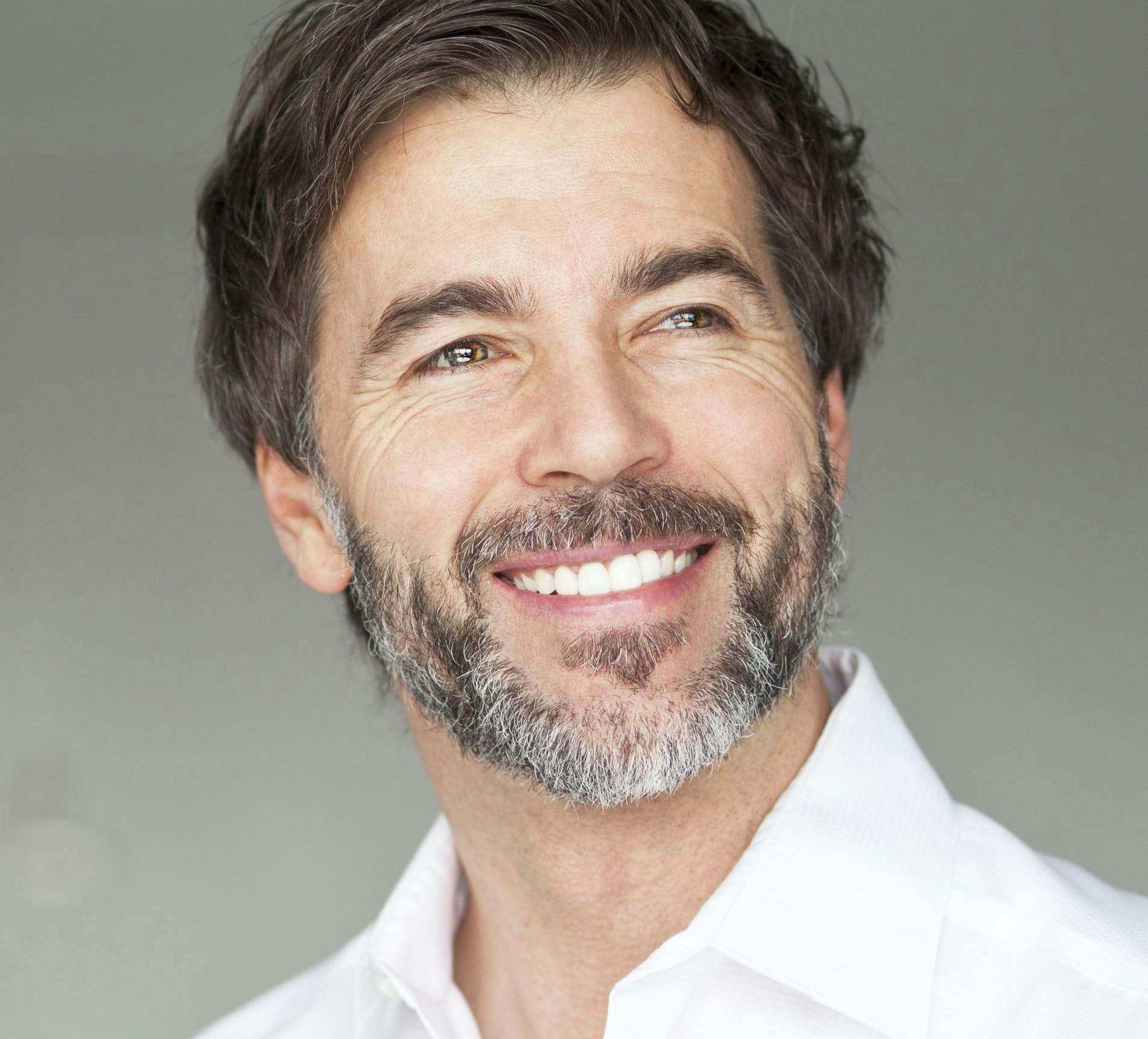 man smiling with some gray in his beard