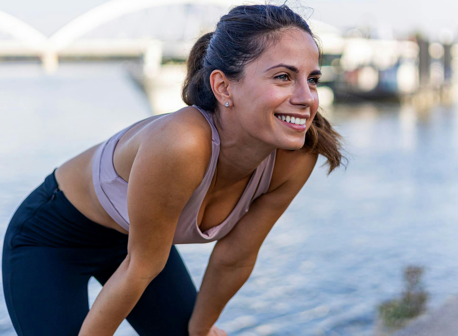 woman on a run leaning over resting her hands on her knees