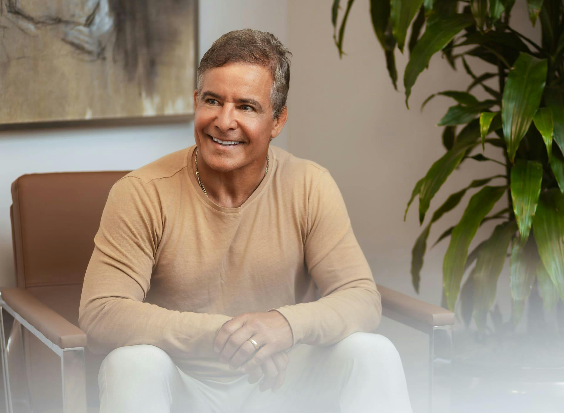 man smiling and sitting in chair