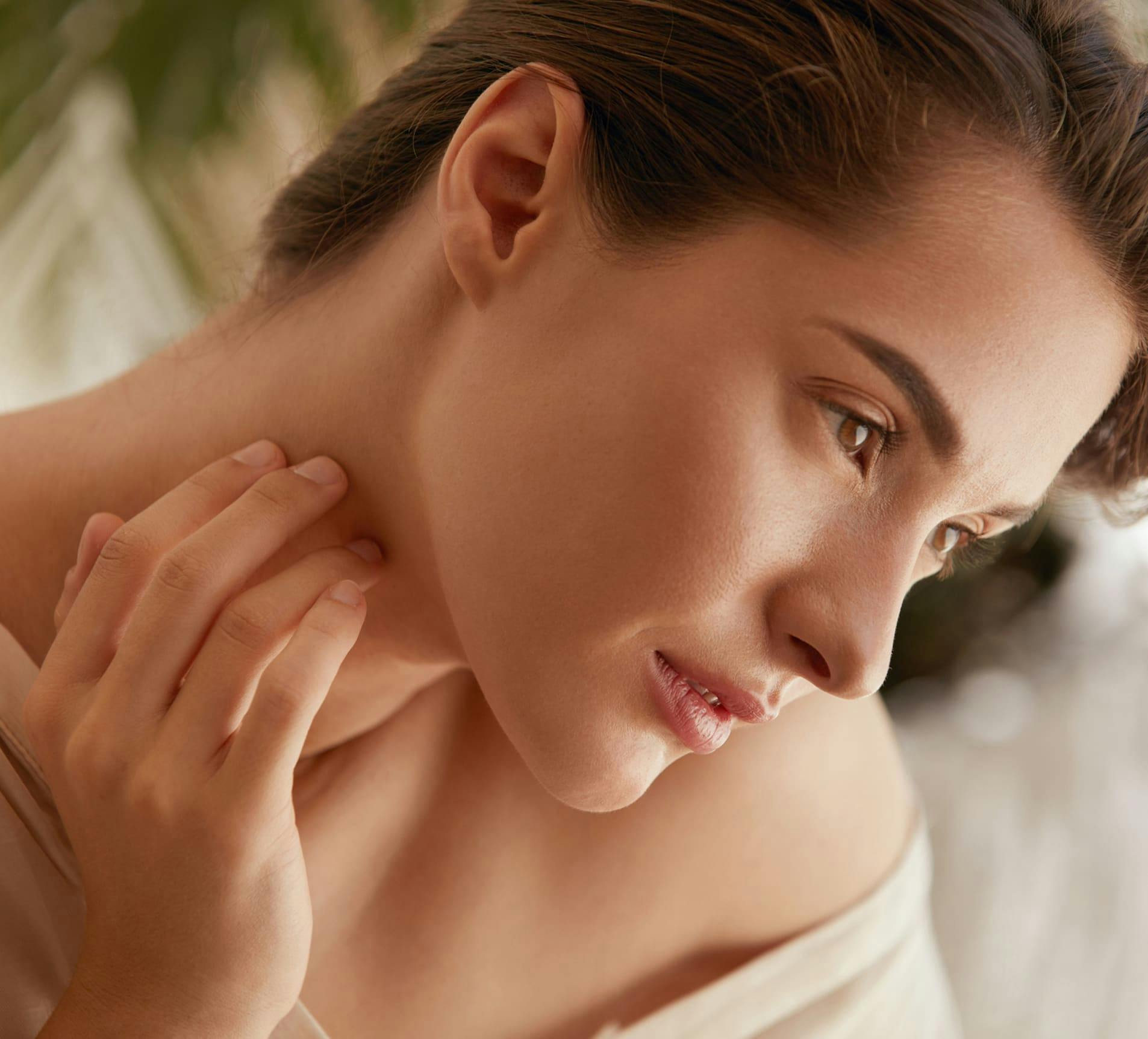 woman touching her neck