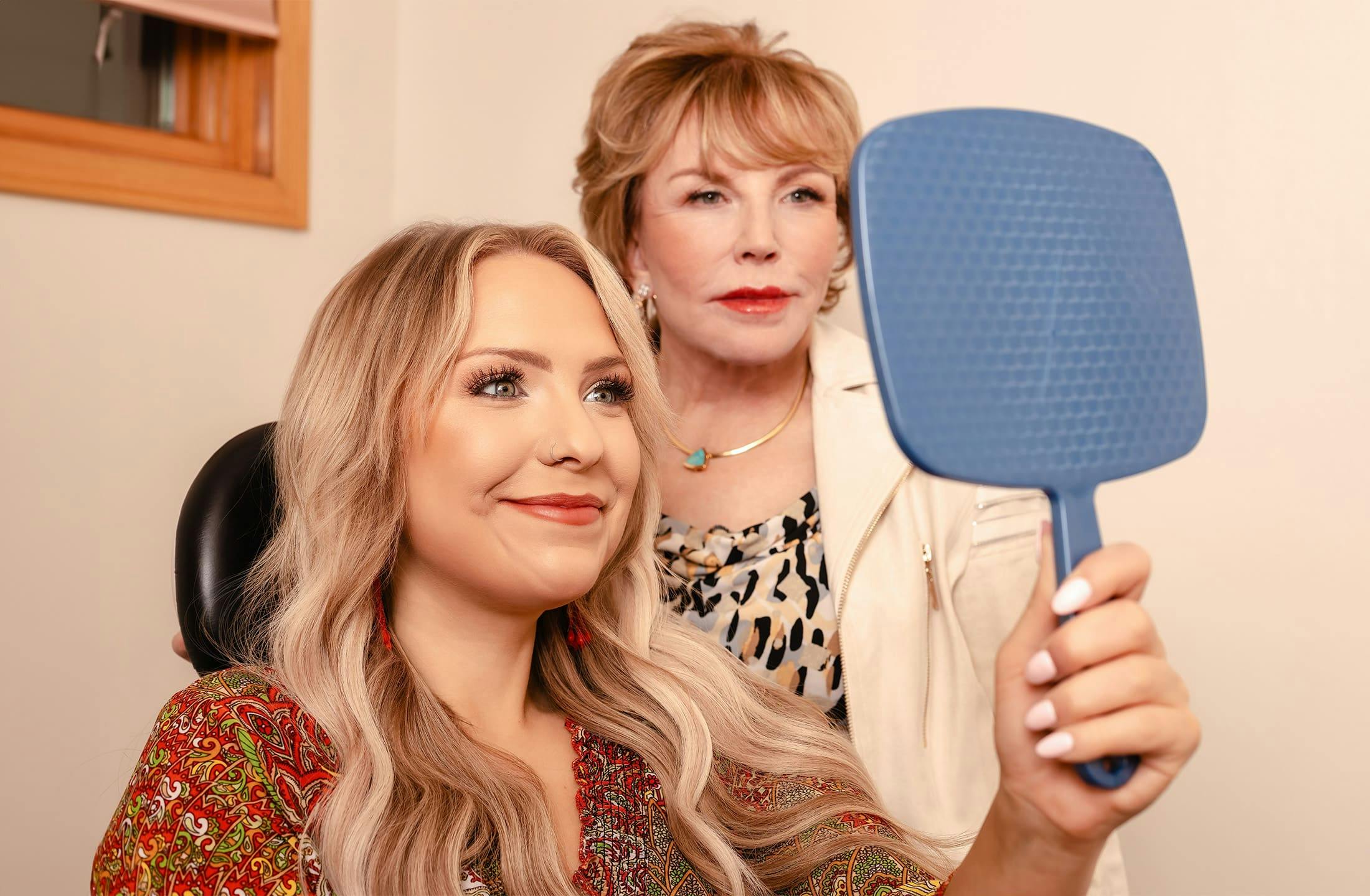 Dr. Duncan with patient as she holds handheld mirror