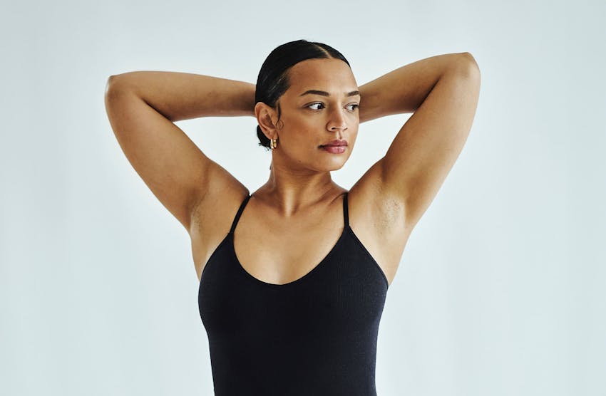 woman raising her arms to rest behind her head