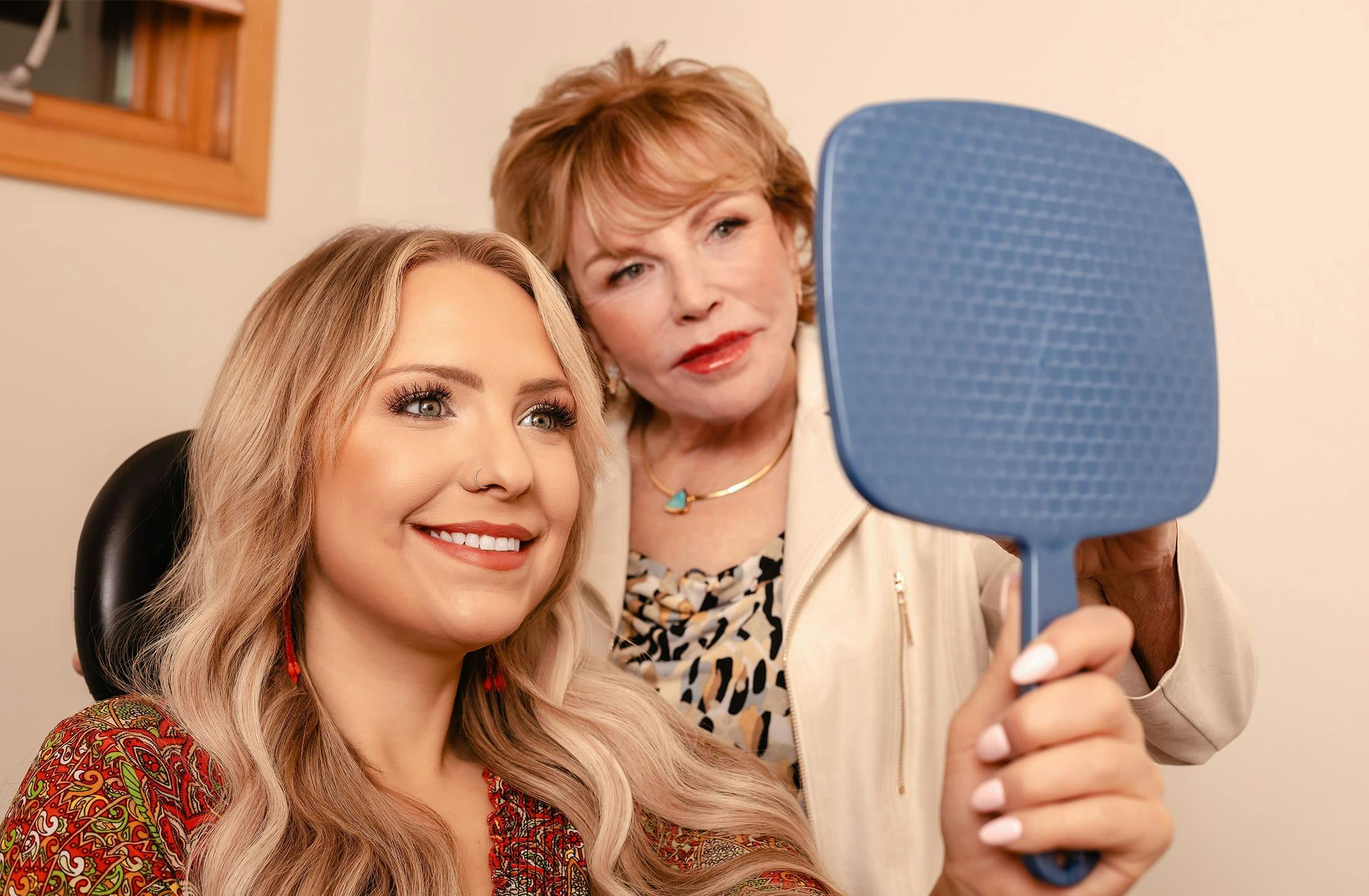 Dr. Duncan looking in handheld mirror with patient