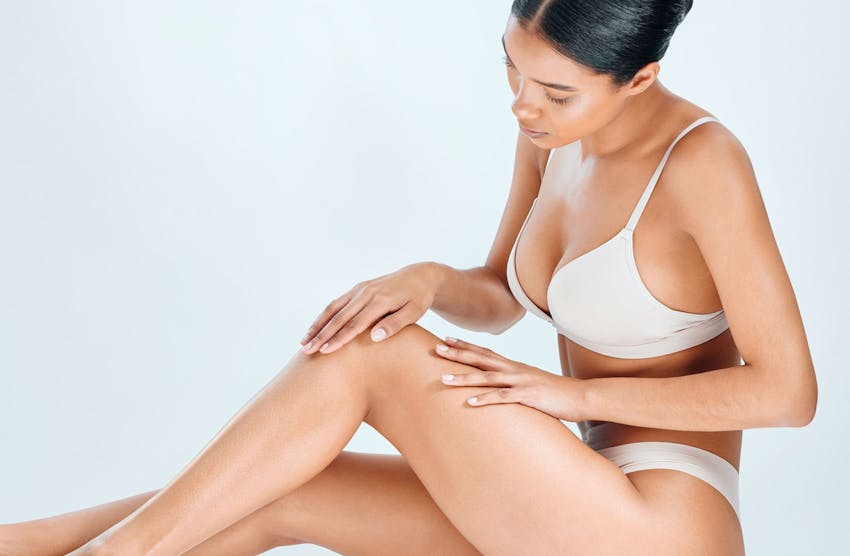 woman sitting and looking at her bent leg