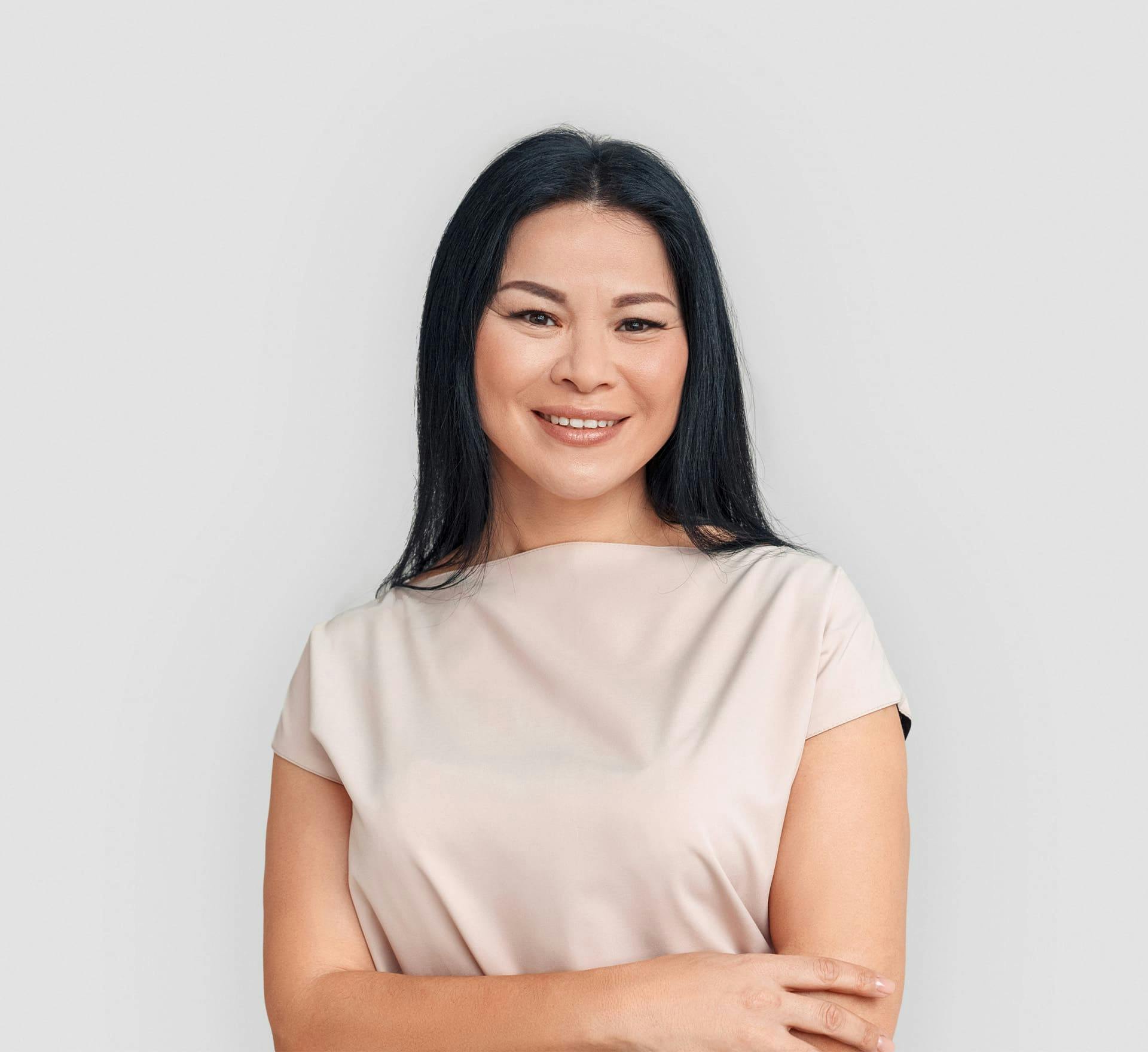 asian woman smiling with her arms crossed