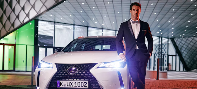 license plate, formal wear, suit, adult, male, man, person, car, tie, car dealership