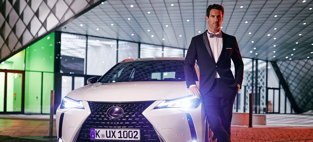 license plate, formal wear, suit, adult, male, man, person, car, tie, car dealership