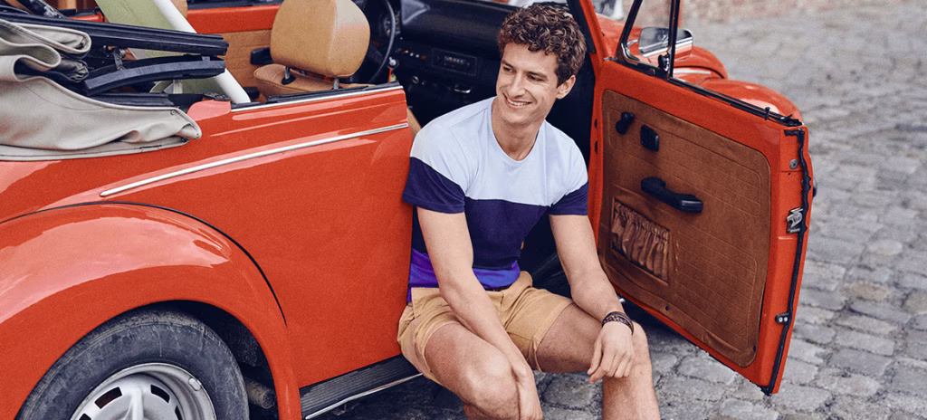 adult, male, man, person, clothing, shorts, chair, furniture, car, sitting