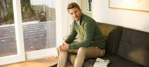 person, sitting, couch, furniture, clothing, knitwear, sweater