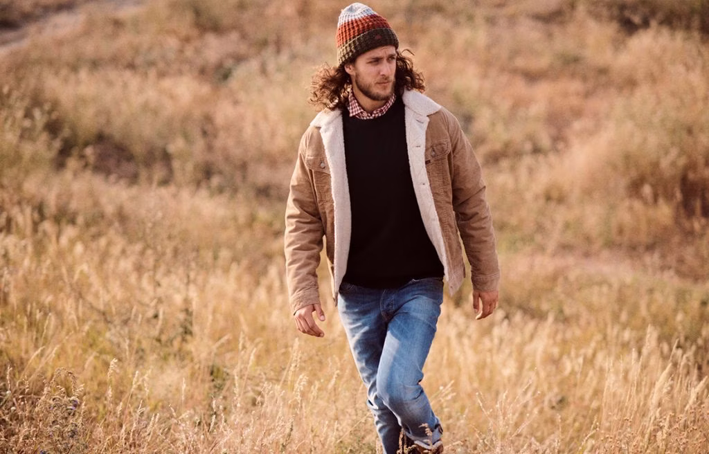 pants, coat, jacket, adult, male, man, person, hat, jeans, necklace