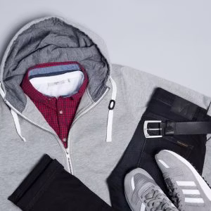 Zur dunklen Jeans passen die Sneaker und die Kapuzenjacke in Hellgrau perfekt dazu. Mit einem Karohemd in Rot und Blau peppst Du das Outfit noch auf.
