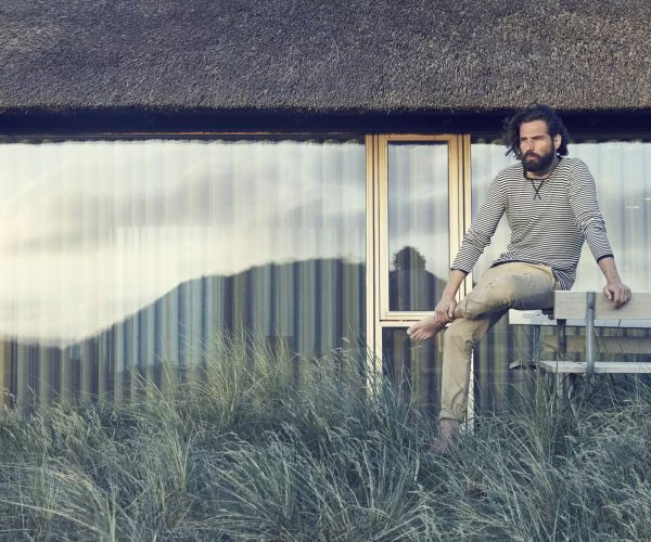 adult, male, man, person, pants, outdoors, shelter, sitting, necklace, bench