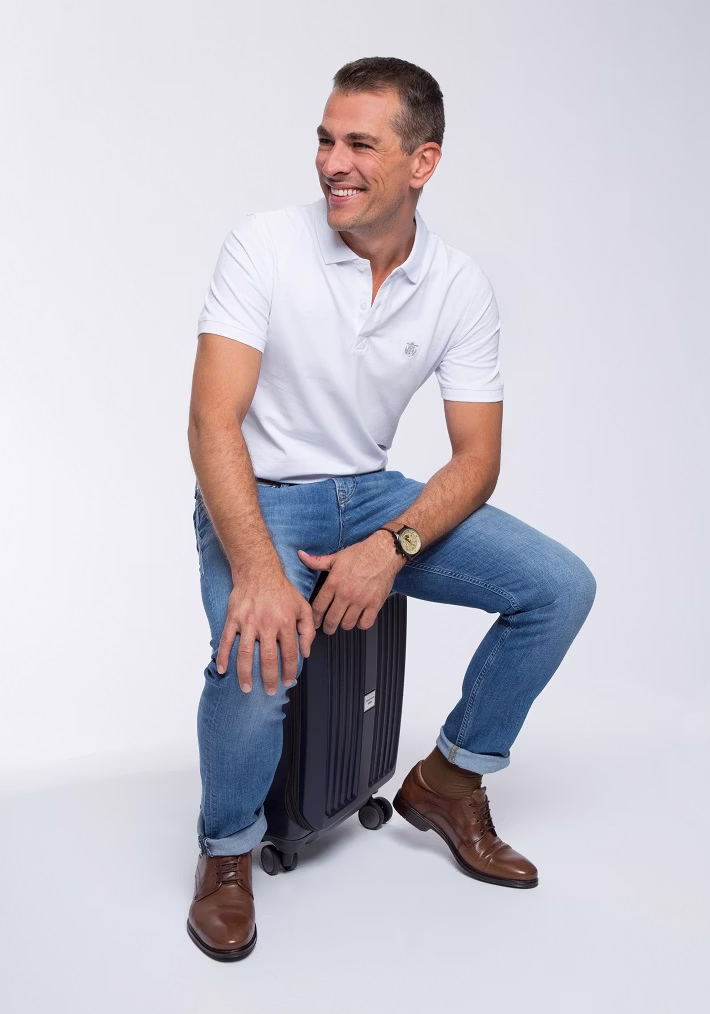 person, sitting, adult, male, man, clothing, pants, wristwatch, shoe, portrait