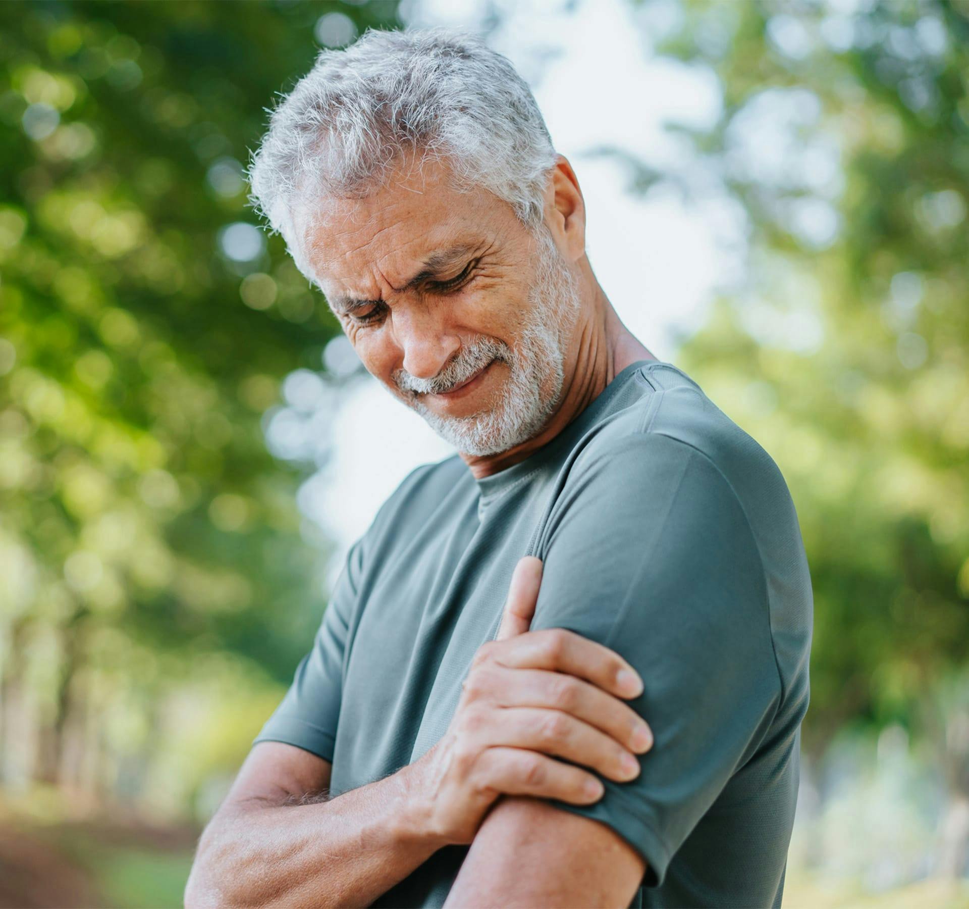 older man holding his arm in pain