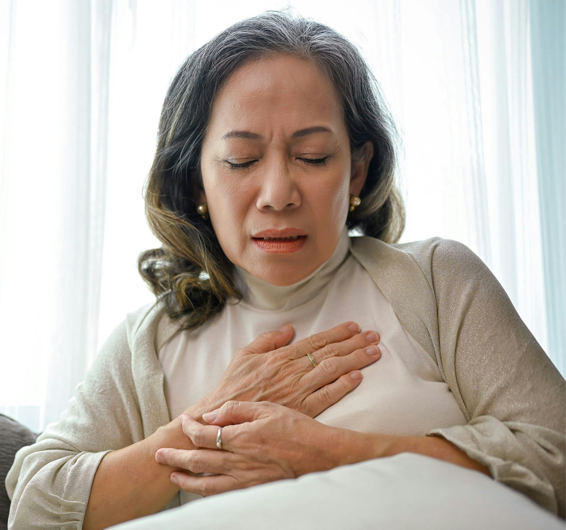 woman in pain holding her chest