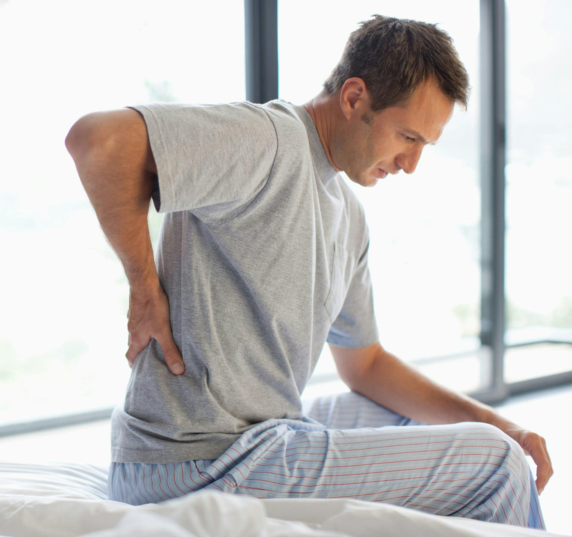 man holding his lower back in pain