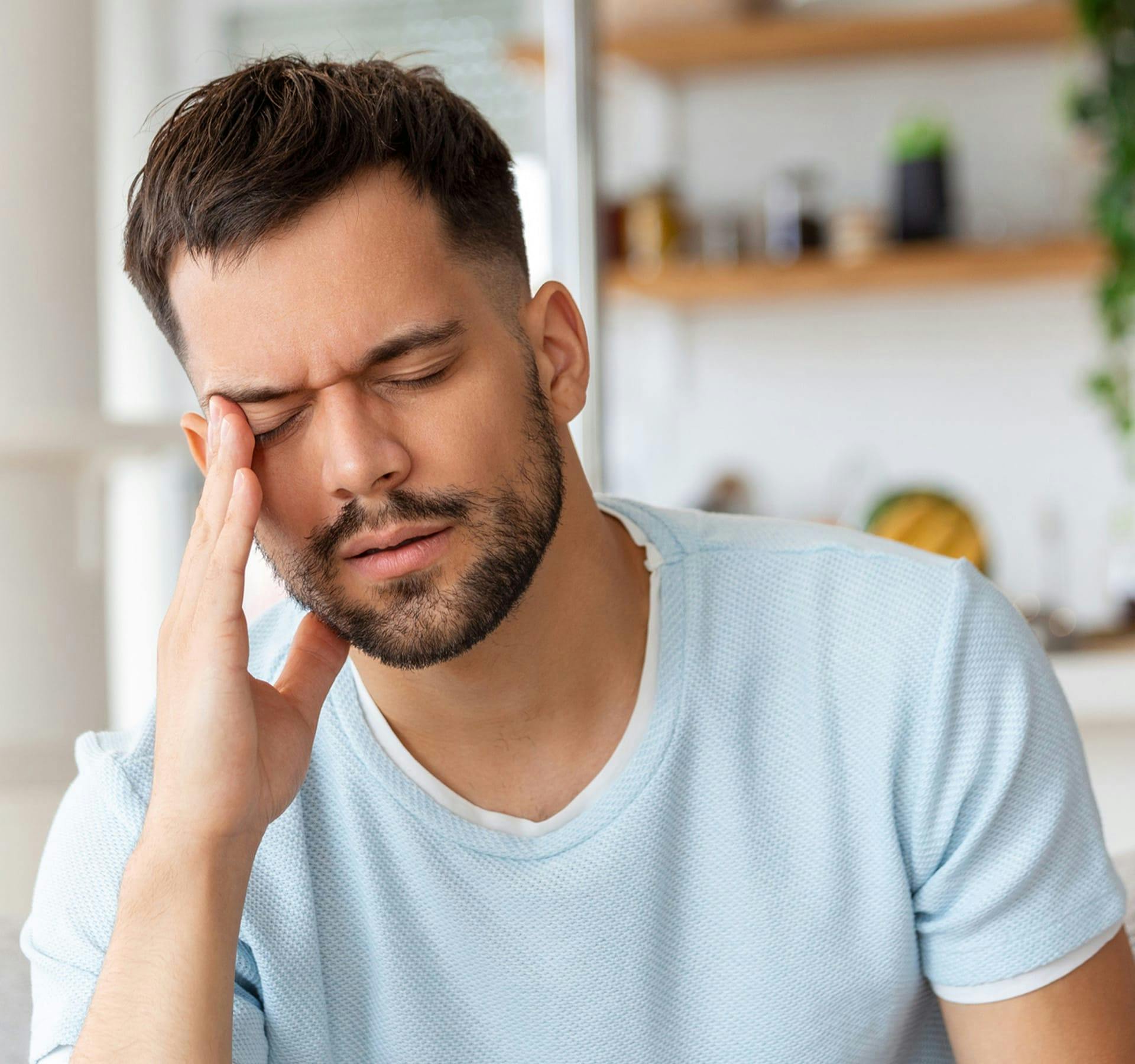 man in pain touching his temple