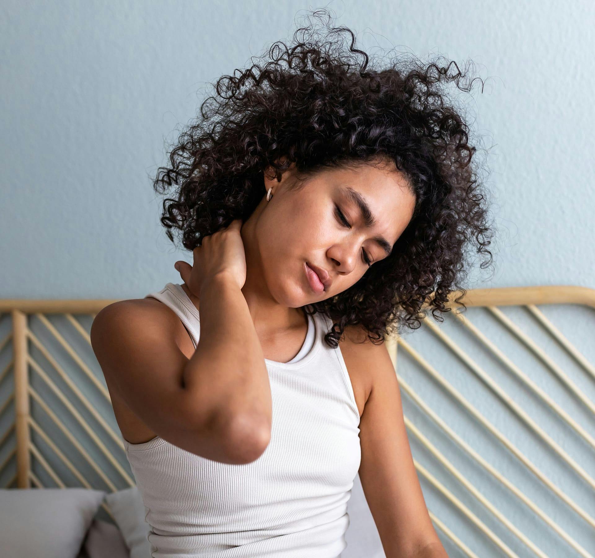 woman touching her neck in discomfort