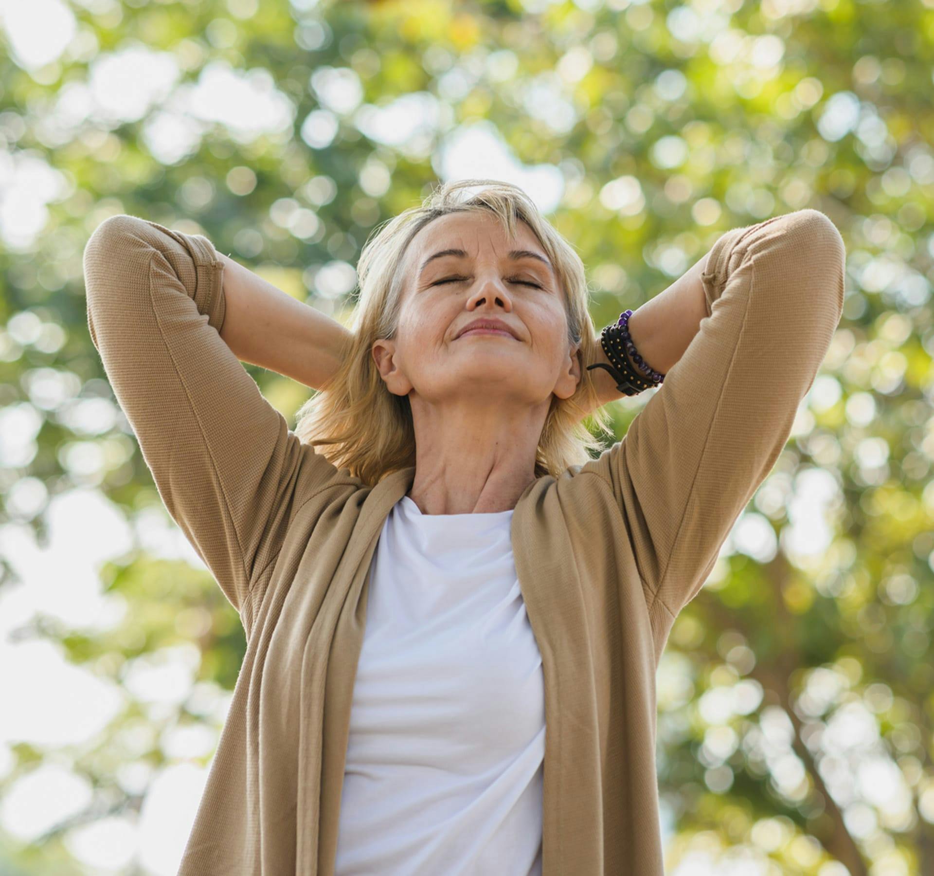 older woman smiling holding her hair