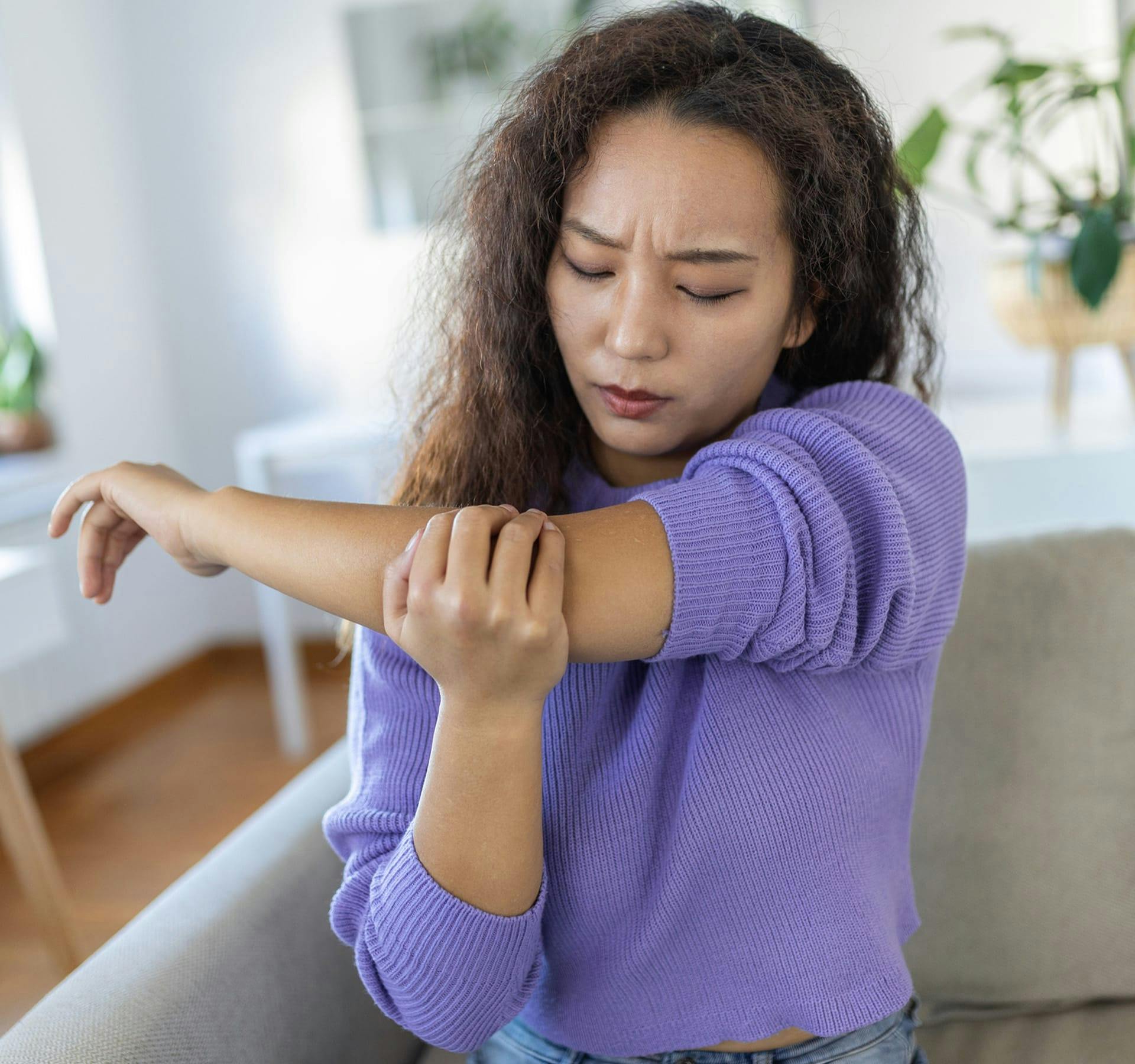 woman holding her elbow in pain
