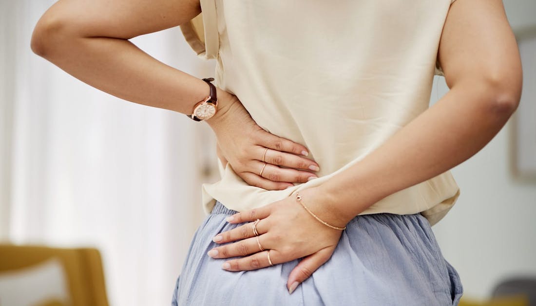 woman holding her lower back
