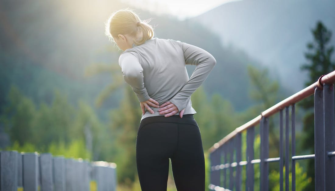 woman holding her lower back in pain