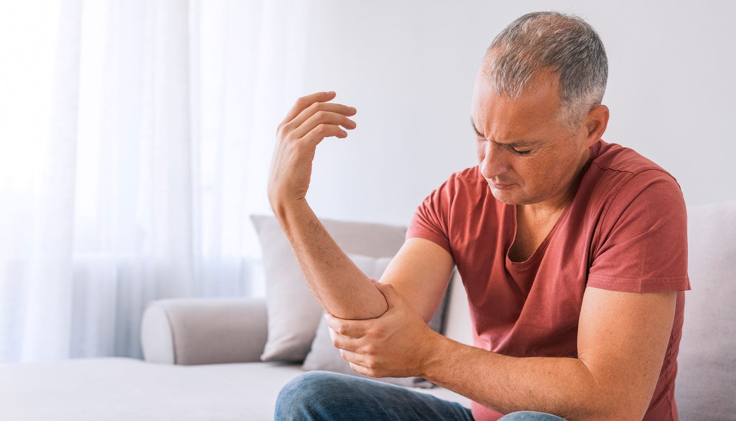 man holding his arm uncomfortable