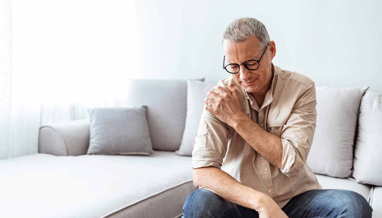man holding his shoulder in pain