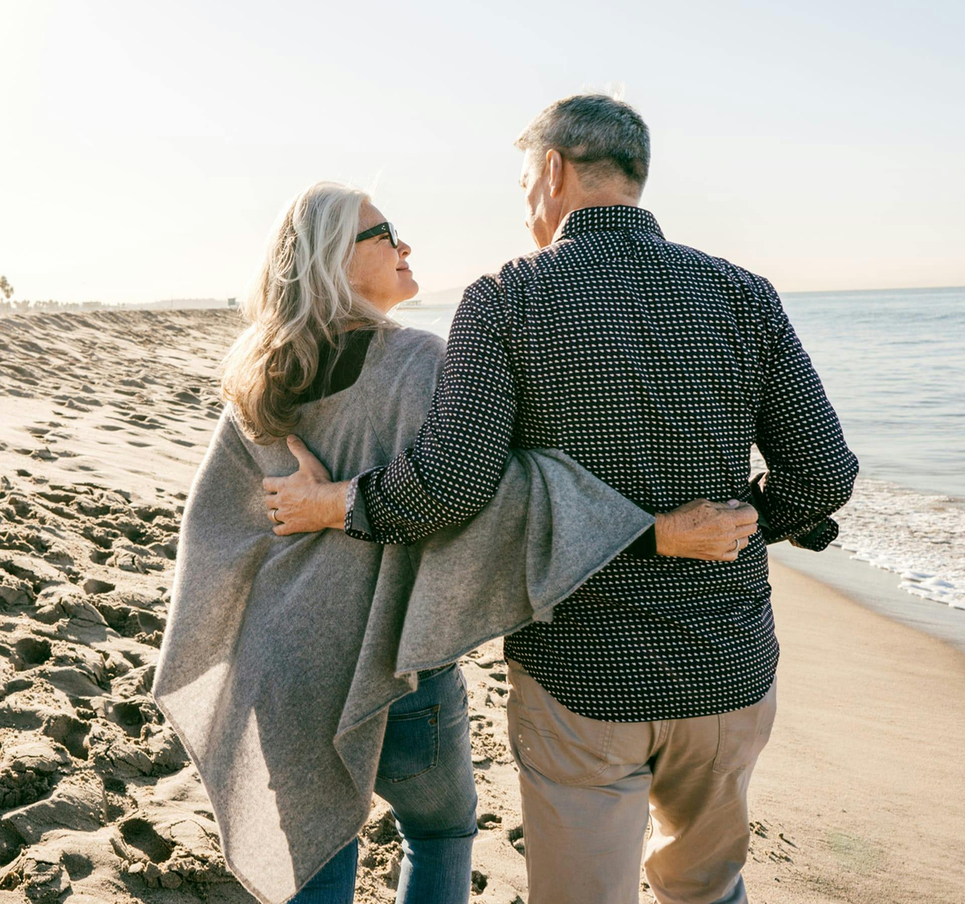 two people walking on the beach