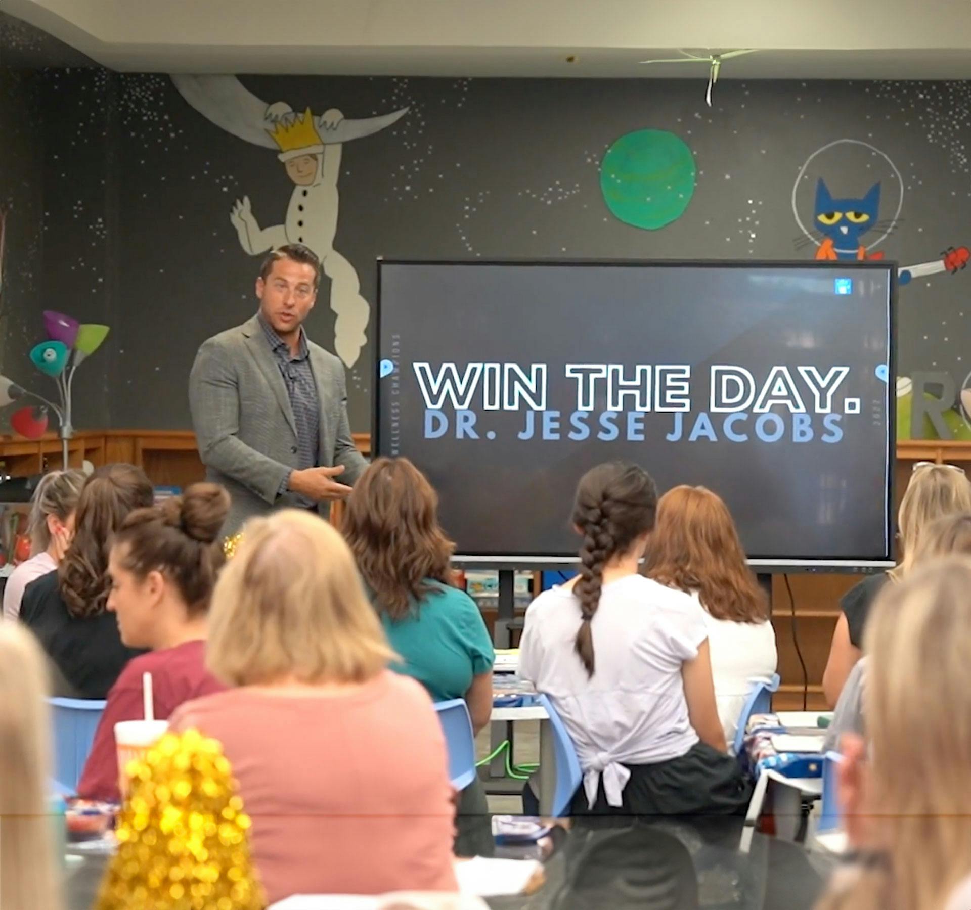 Chiropractor talking to group of kids