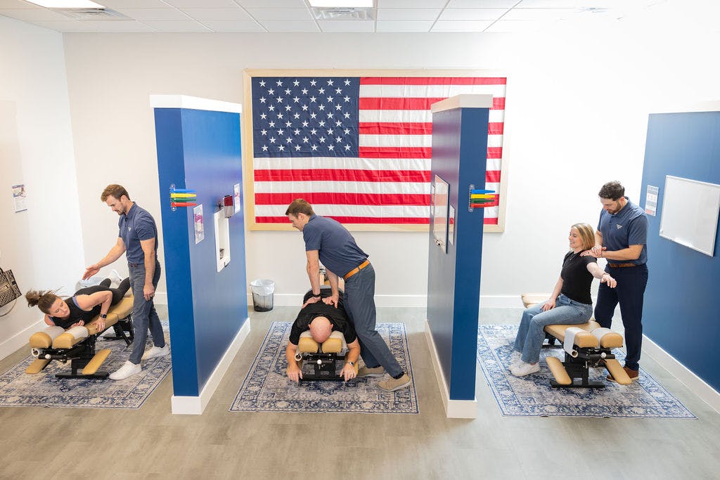 CHiropractic Offices of Freeform Chiropractic. Showing 3 people getting adjustments at the same time with wall perissions inbetween each person.