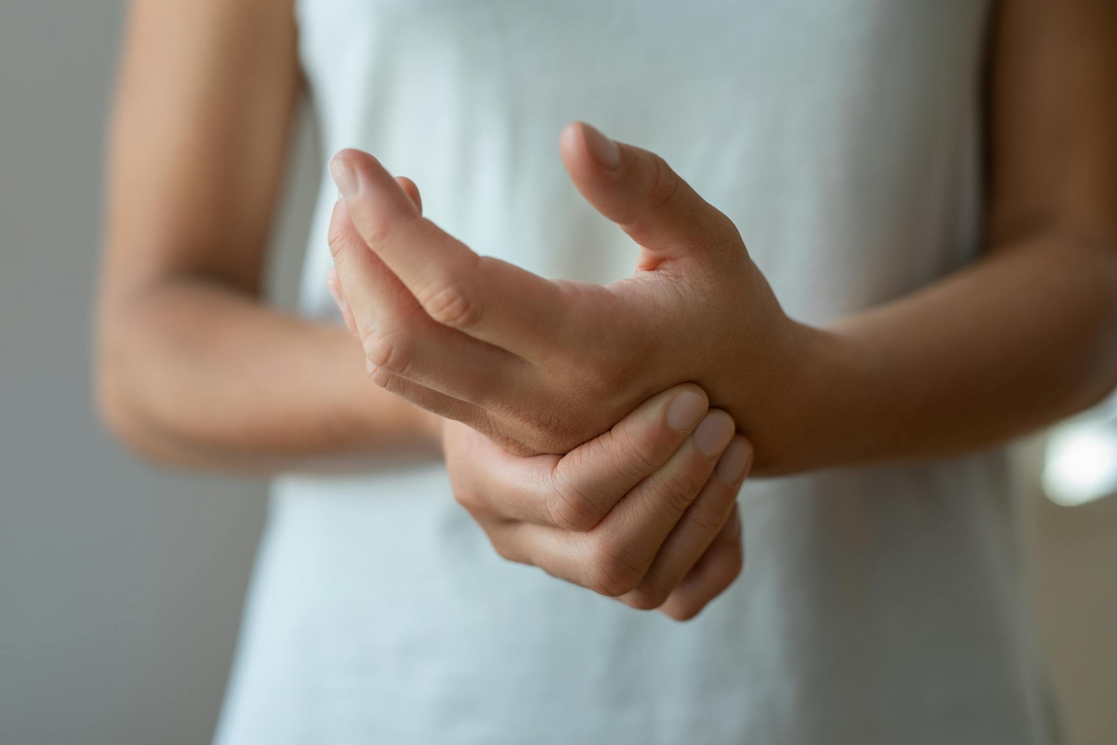 Woman rubbing her hand due to nerve pain
