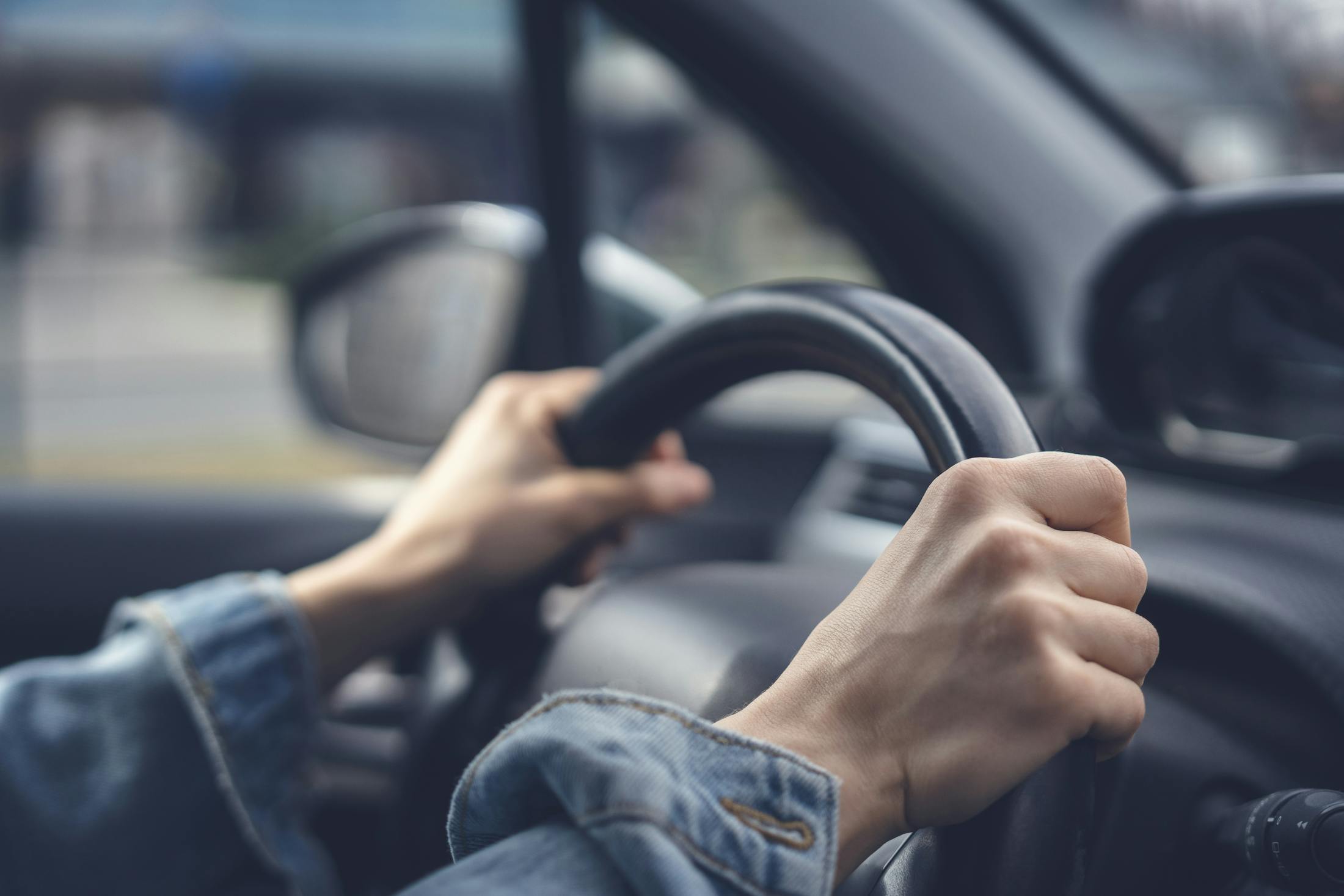 woman's hands on the steering wheel of a car