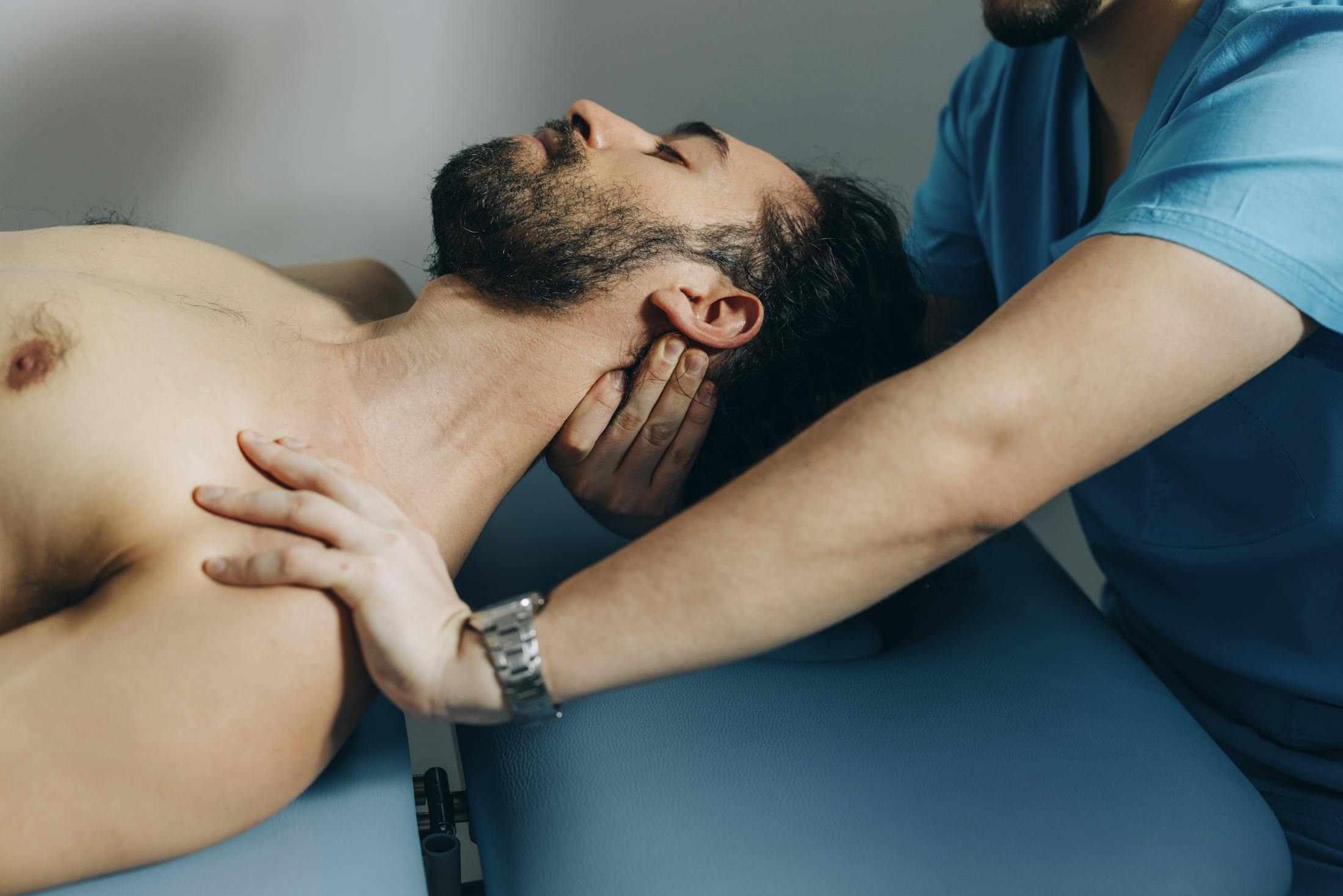 man is having his neck adjusted by a chiropractor