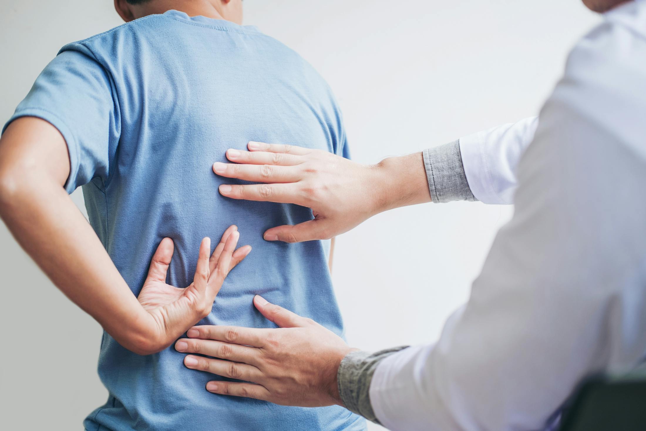man showing his chiropractor where he is having pain in his back