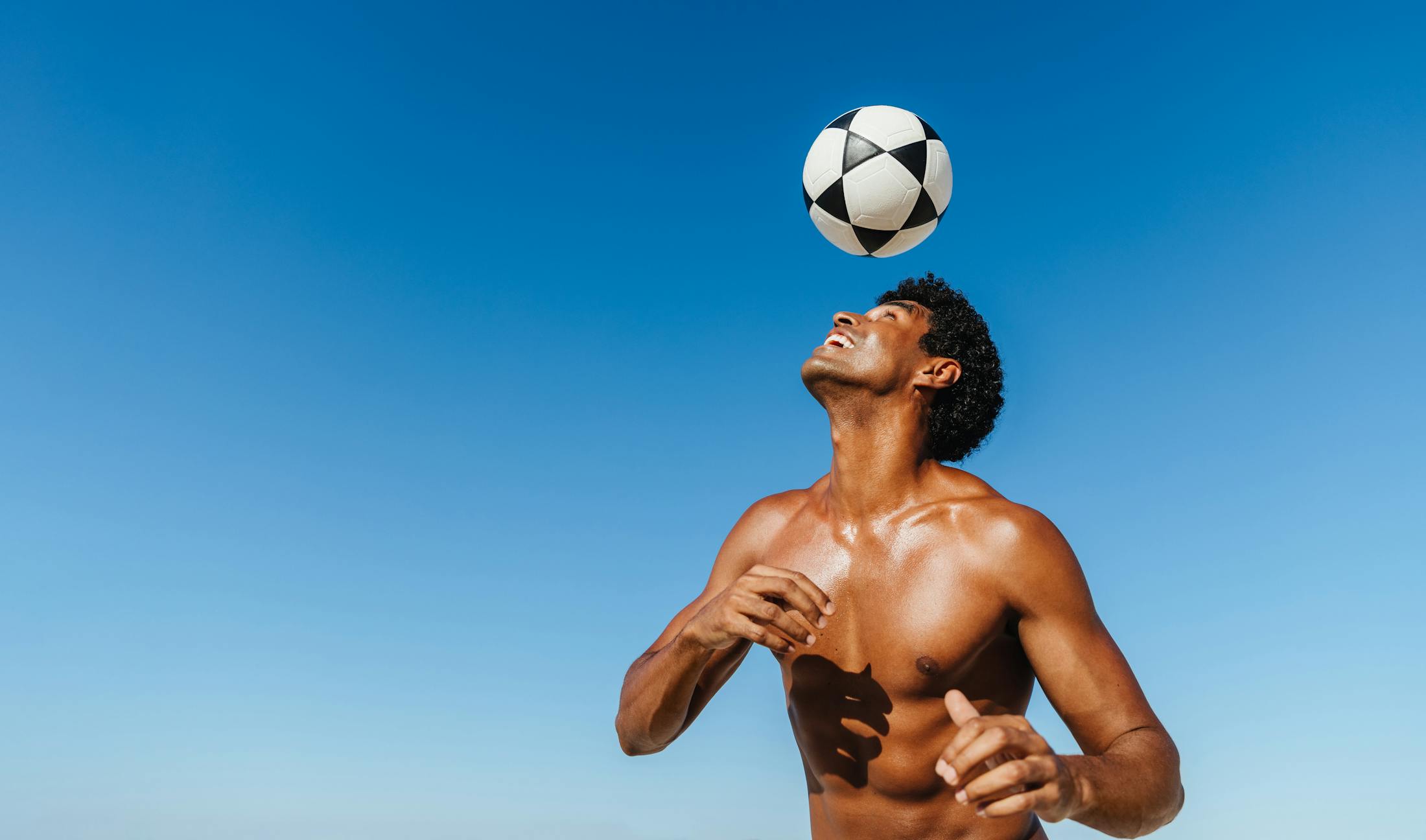 soccer ball in mid air above a mans head
