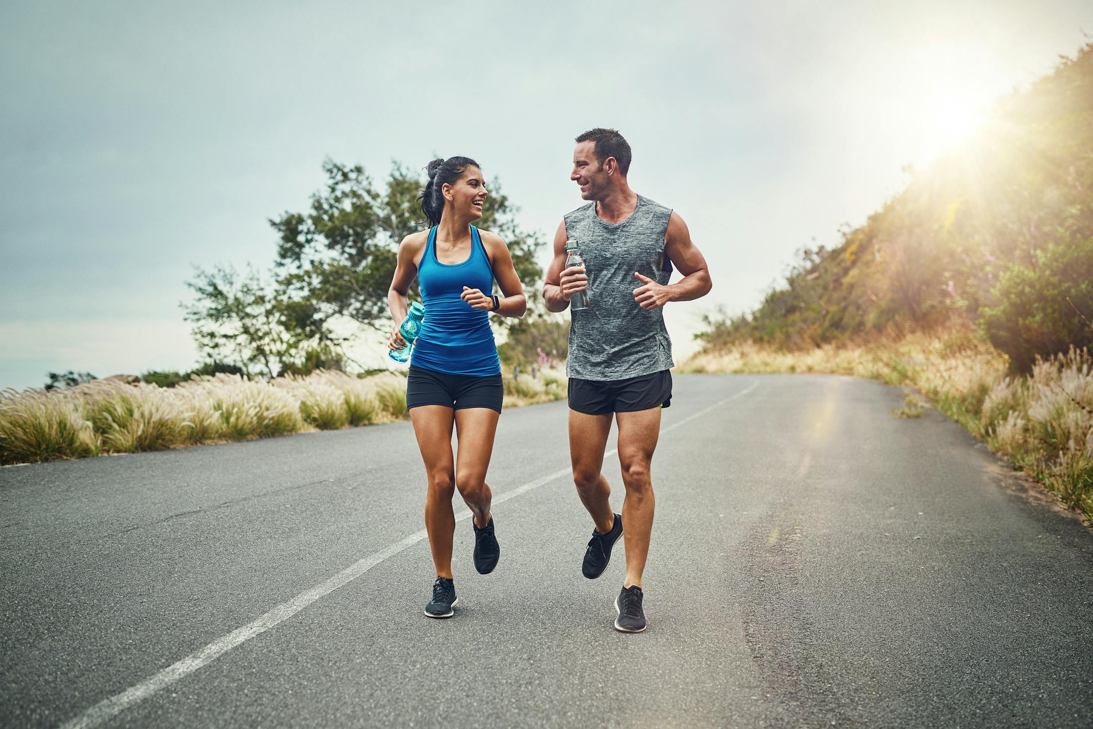 a man and a woman on a run through a hill