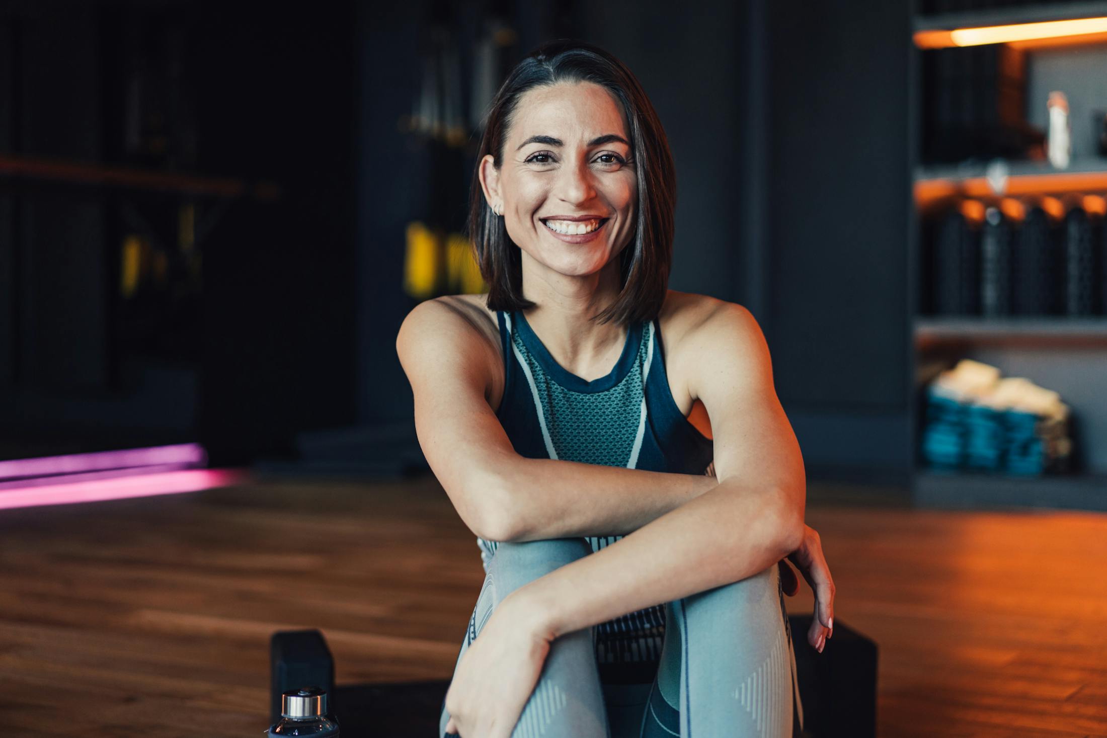 Woman at a workout studio smiling at the camera after finishing a workout