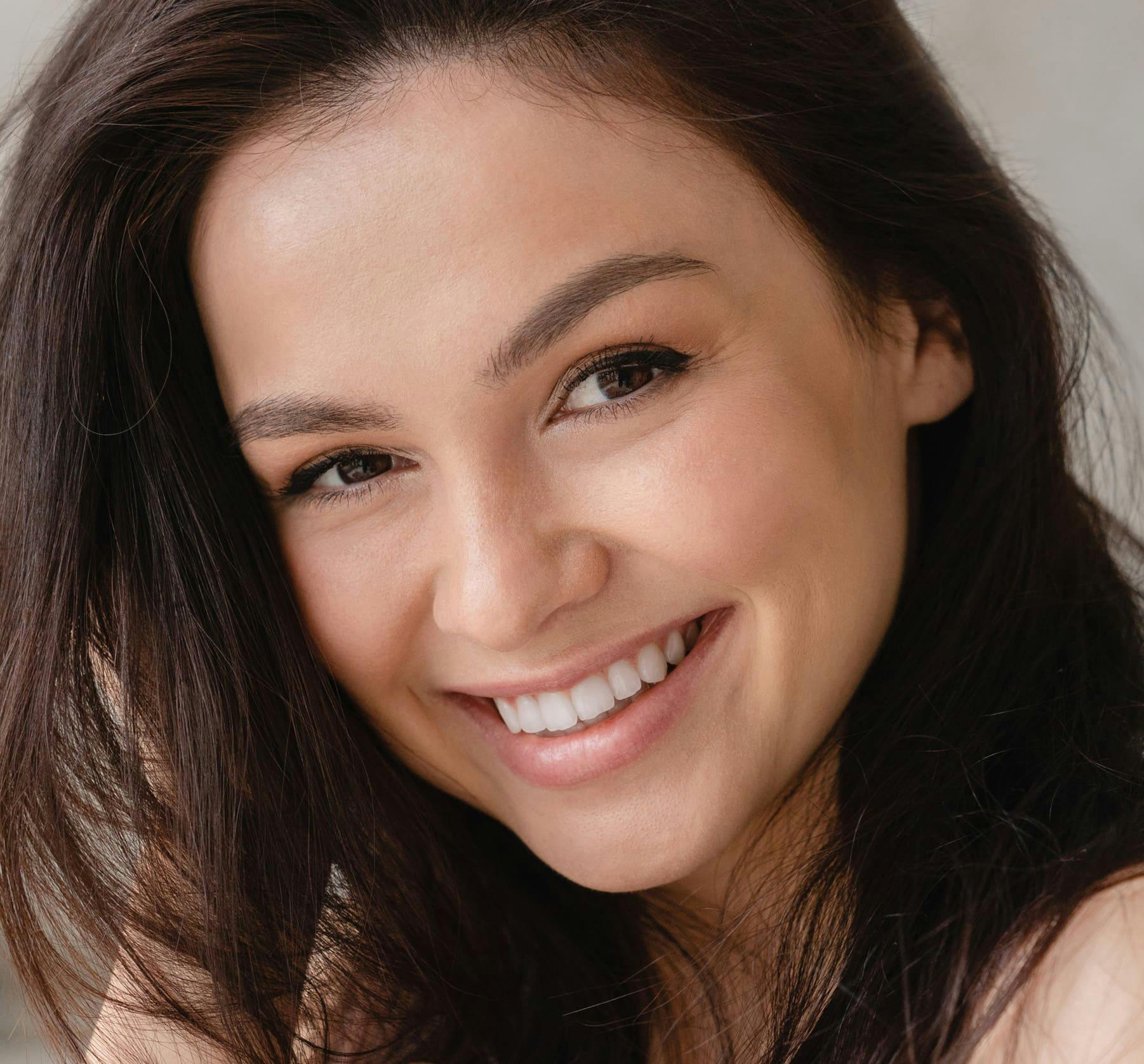 woman smiling with her hand in her hair