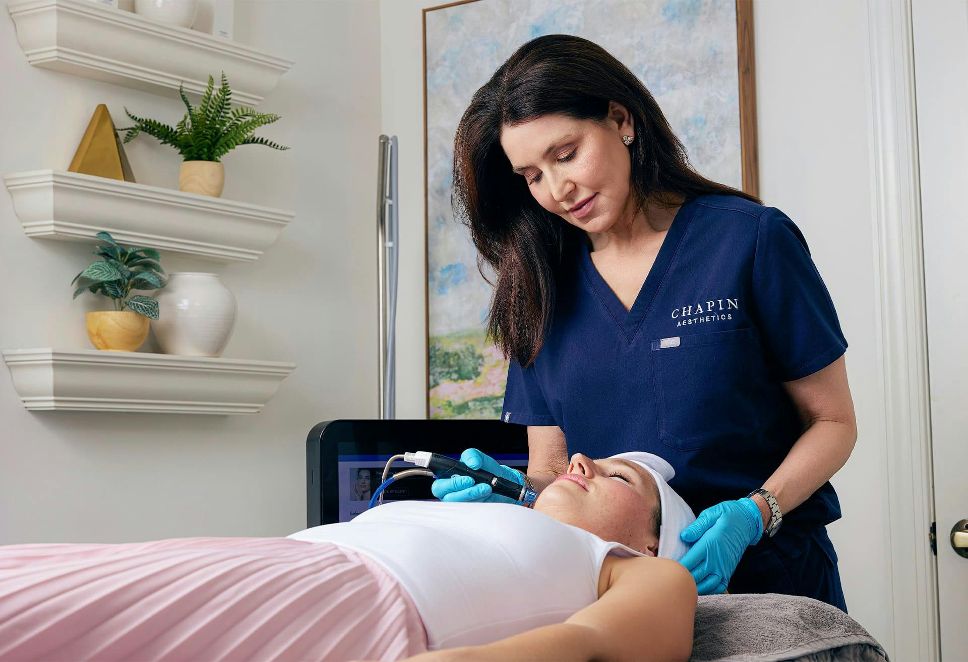 staff member doing facial procedure