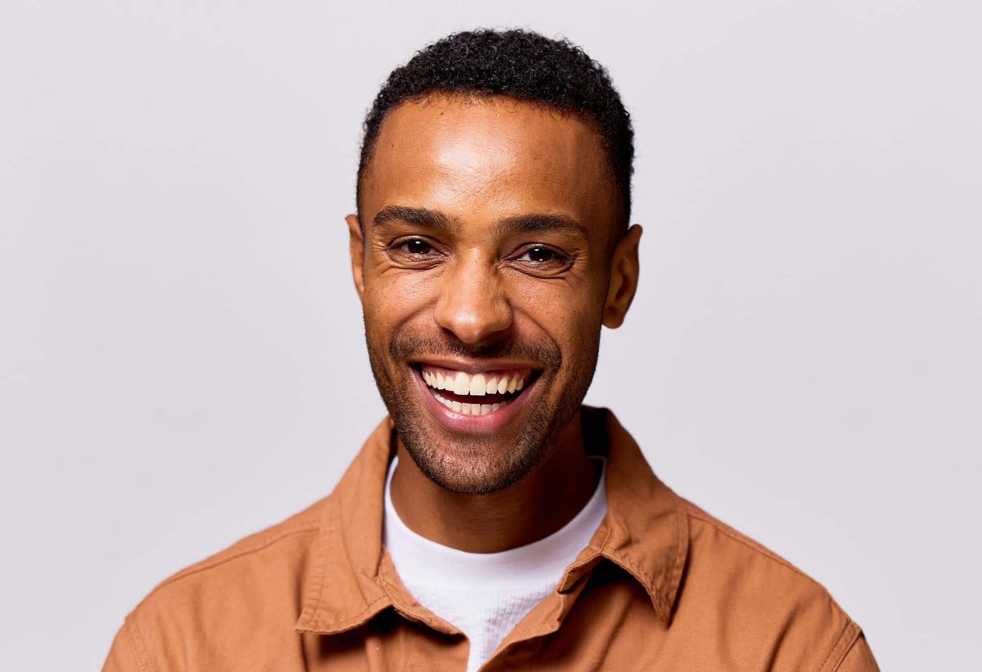 man smiling forward in orange shirt