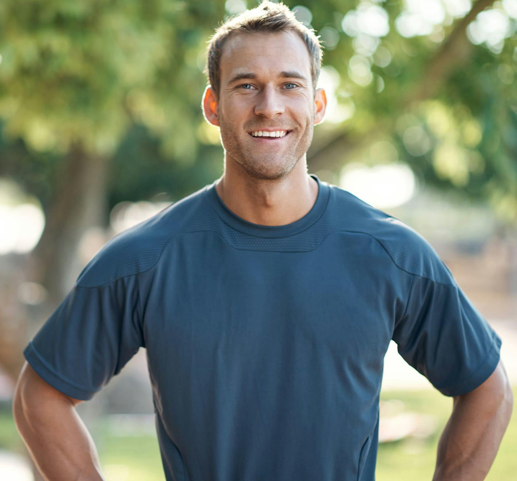 man in navy blue t-shirt with his hands on his hips