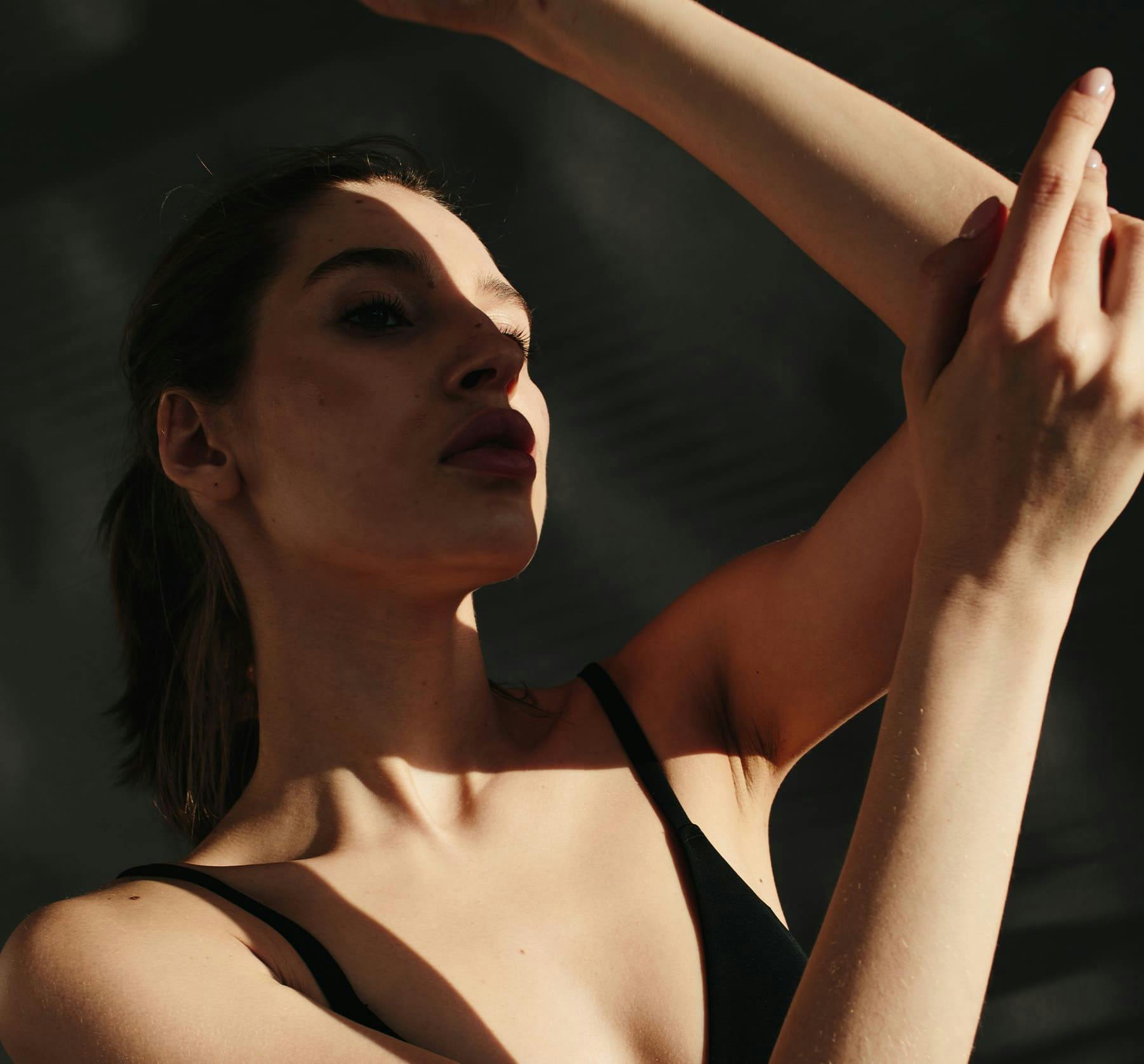 Woman with arms up in the shadow