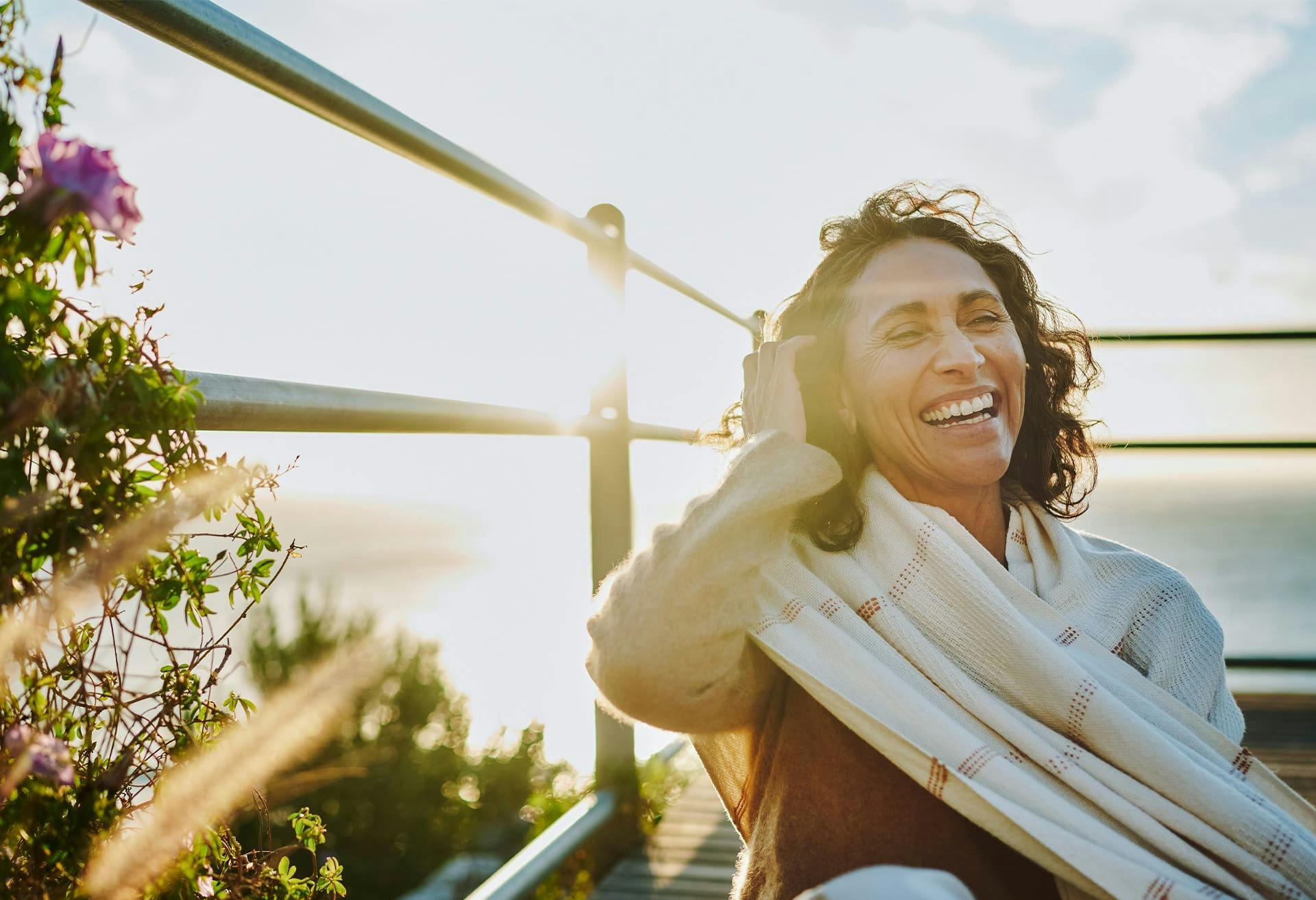 Woman smiling next to a fence