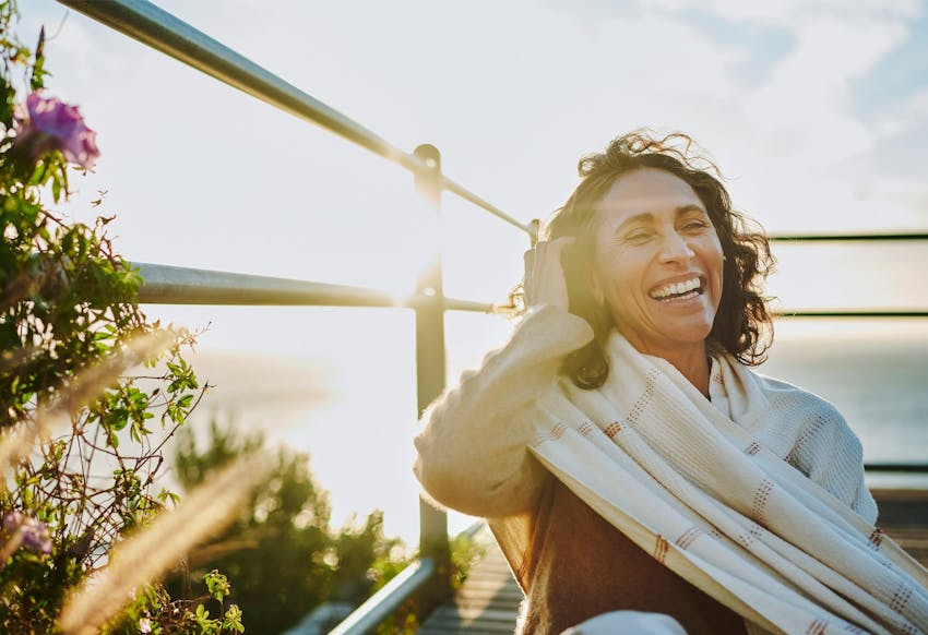 Woman smiling next to a fence