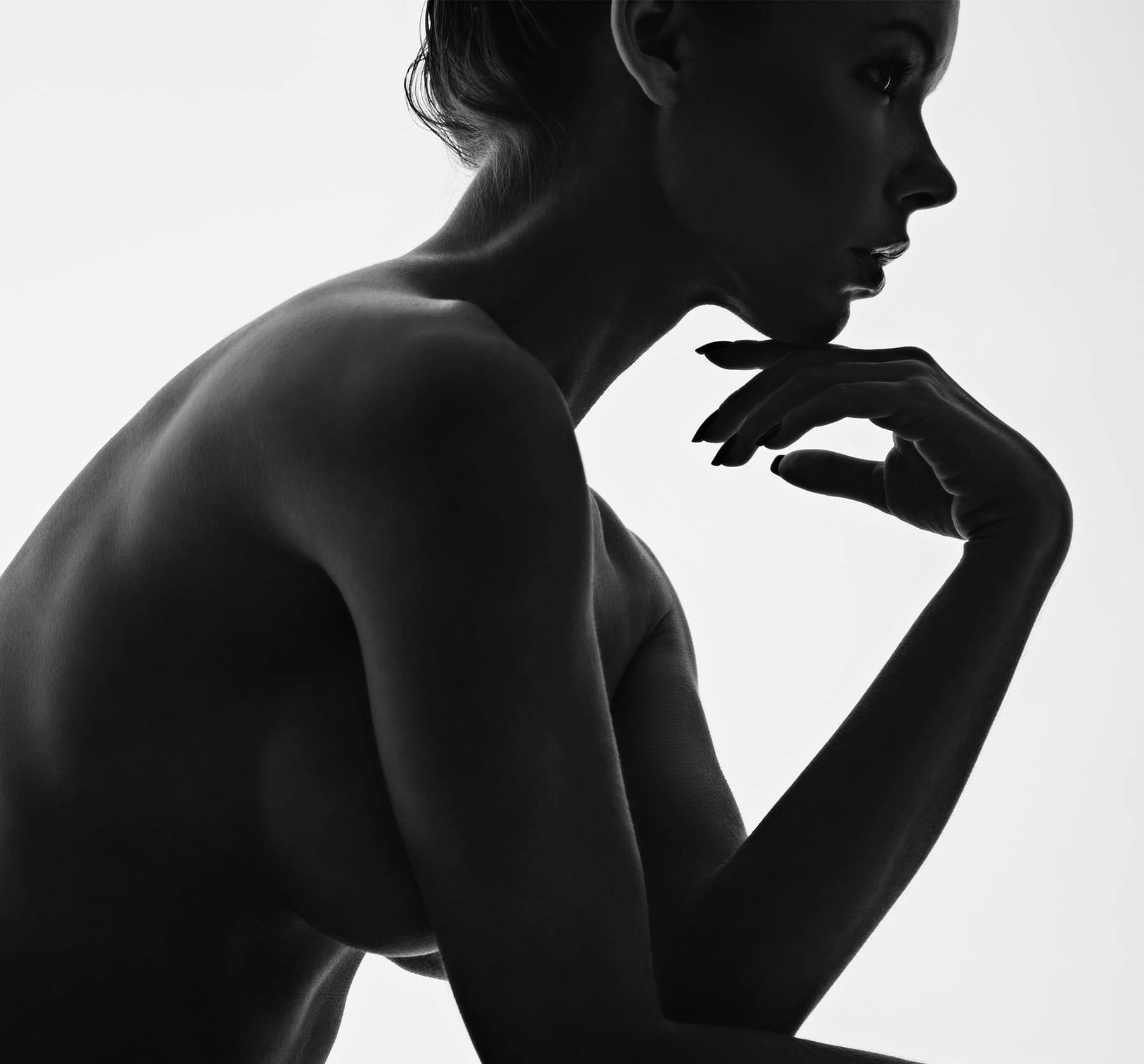 A womans silhouette with her hand touching her chin