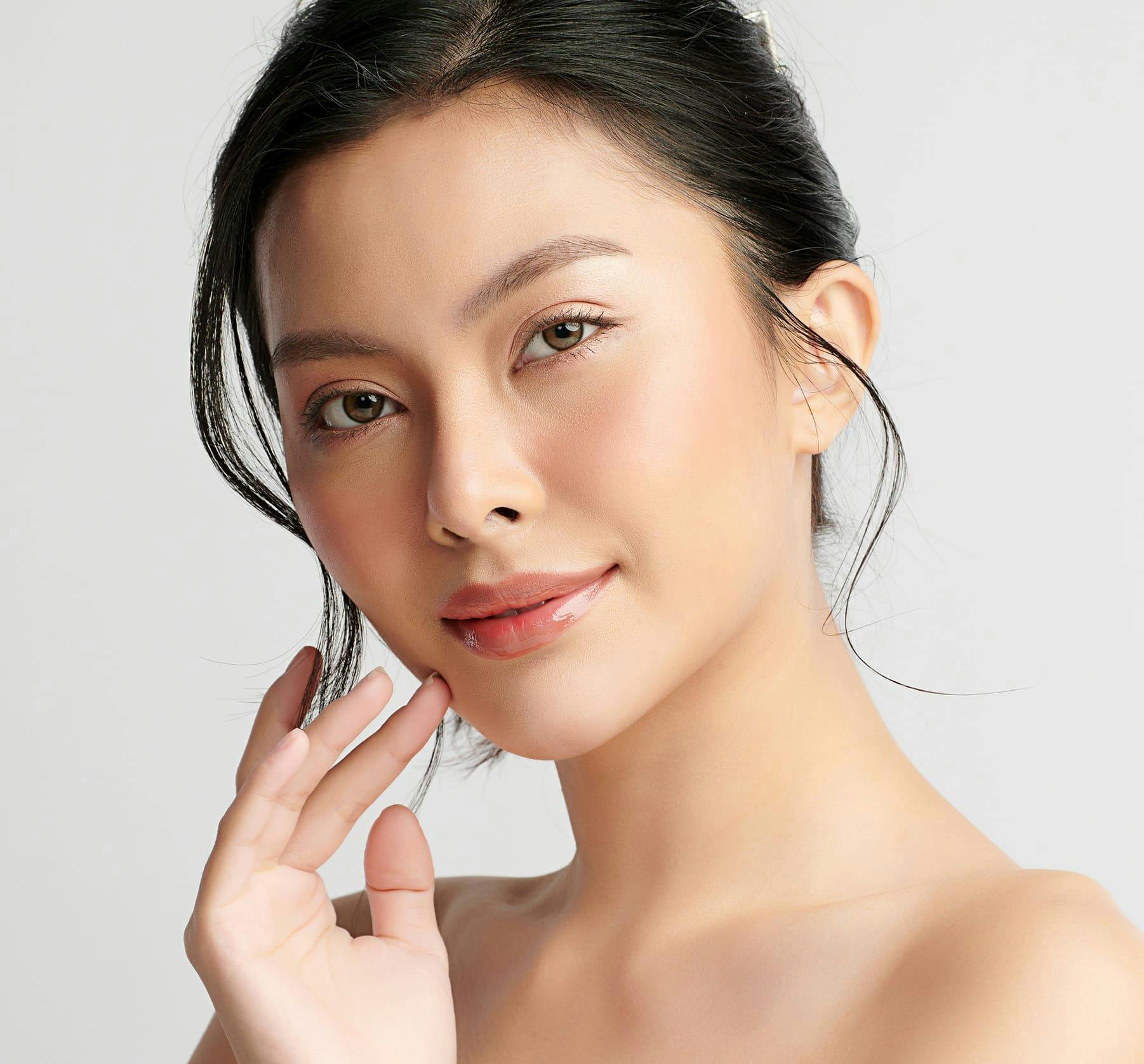 Woman smiling and touching her face