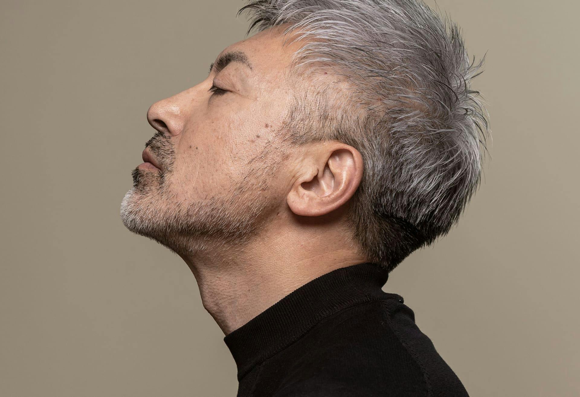 man tilting his head upwards while facing to the side