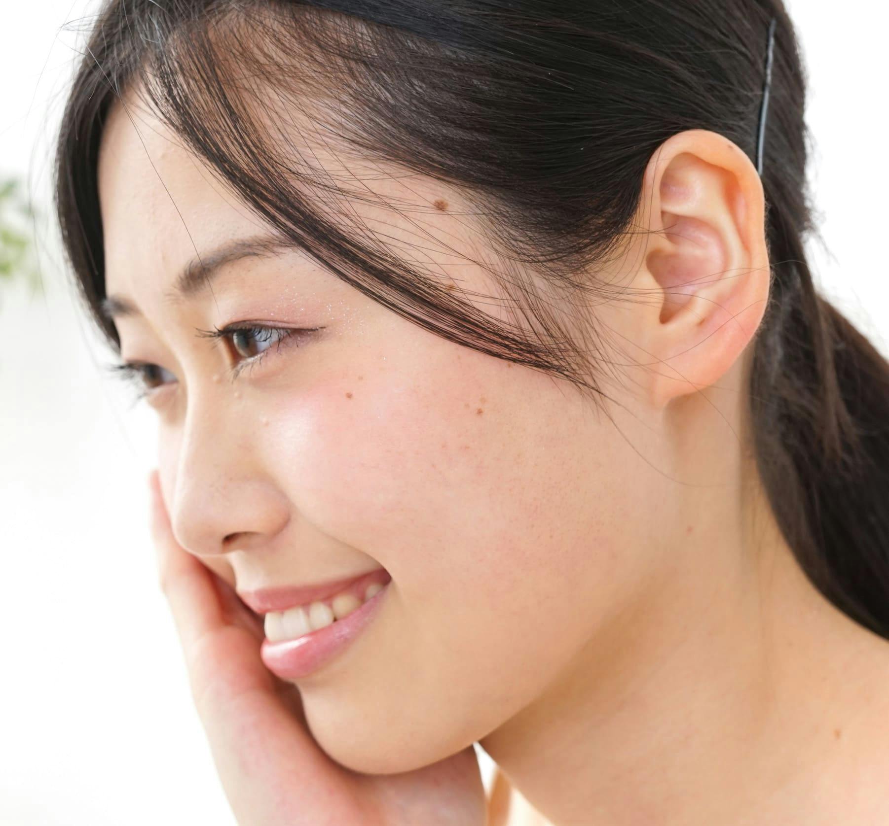 Woman smiling and touching her face